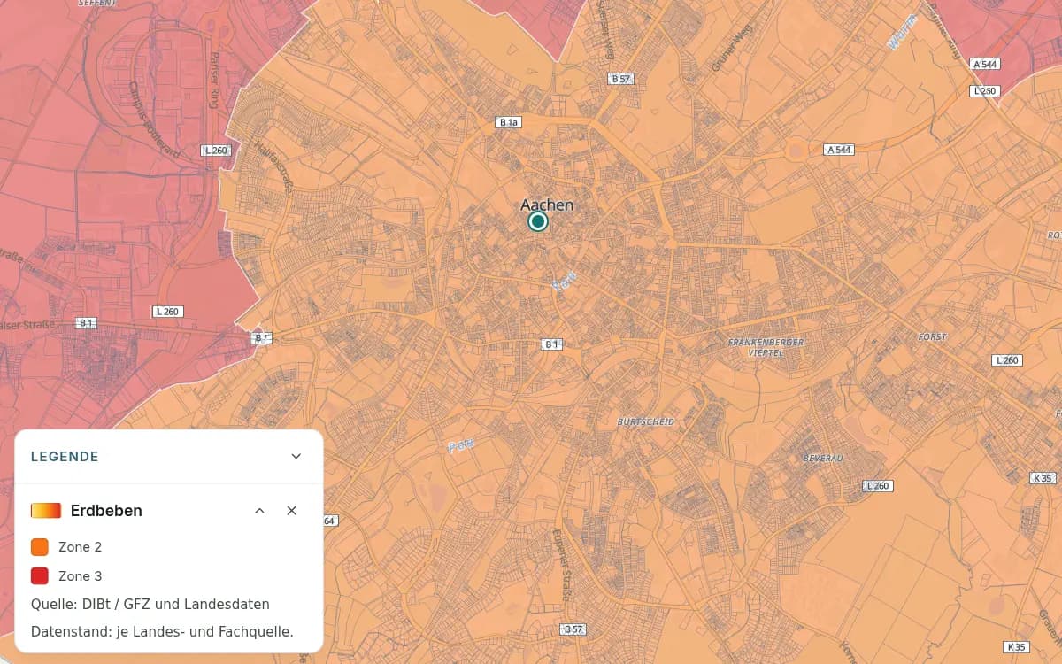 Aachen mit orangefarbenen und roten Erdbebenzonen sowie einer markierten Stelle in der Innenstadt. Die Legende ordnet Orange der Zone 2 und Rot der Zone 3 zu.