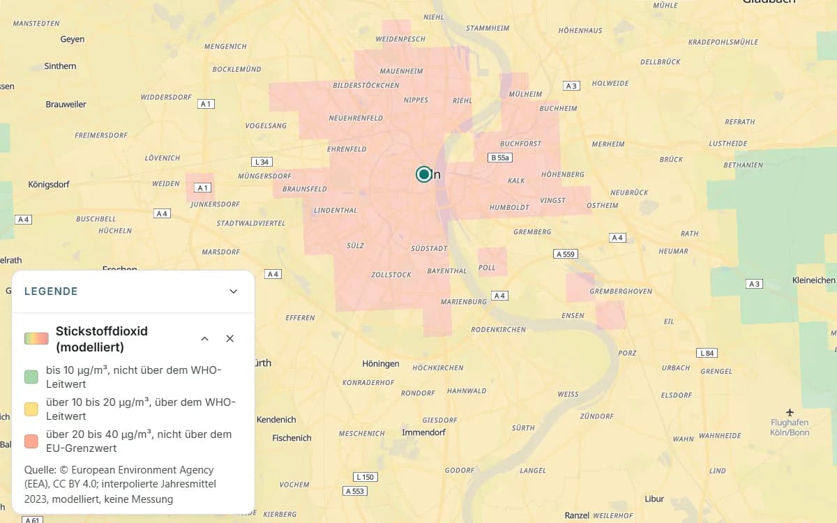 Köln mit farbigen Rasterfeldern und einer markierten Stelle in der Innenstadt. Die offene Legende nennt für jede Farbe eine Stufe des modellierten Jahresmittels für Stickstoffdioxid in µg/m³.