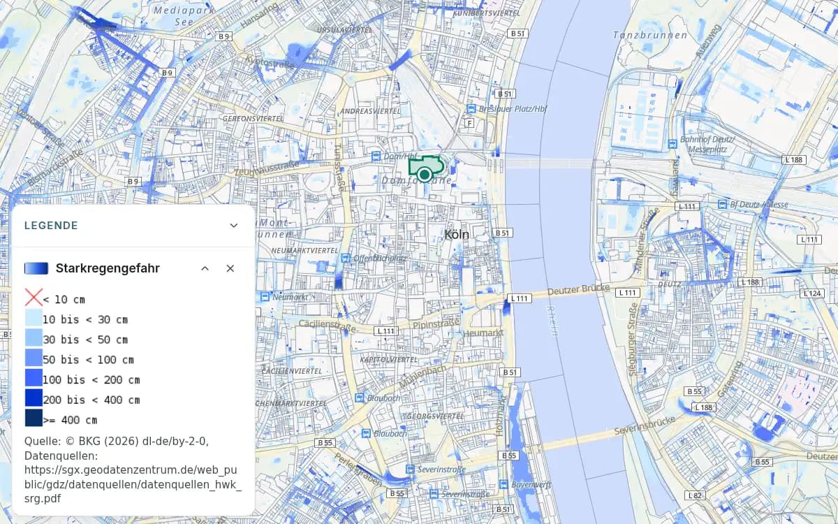 Kölner Innenstadt mit blauen Flächen der Starkregengefahr und einer Markierung am Dom. Die offene Legende zeigt Wassertiefen von unter 10 cm bis ab 4 m; die Stufe unter 10 cm ist durchgestrichen.