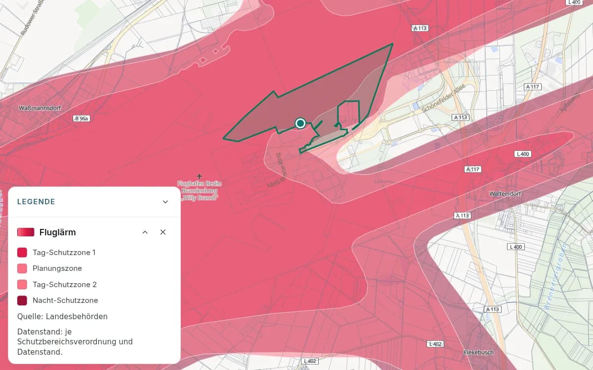 Flughafen Berlin Brandenburg mit überlagernden rosa und roten Fluglärmschutzzonen und einer markierten Stelle. Die Legende unterscheidet Tag-Schutzzone 1, Tag-Schutzzone 2, Nacht-Schutzzone und Planungszone.