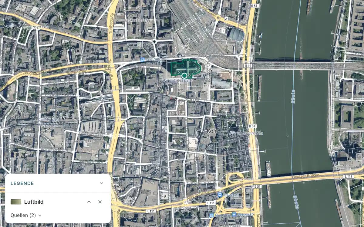 Luftbild der Kölner Innenstadt mit Dom, umliegender Bebauung und Rhein; der Beispielpunkt bleibt markiert.